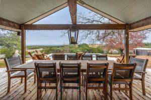 a wooden table and chairs on a deck at Pool, Porch & Stunning Views: Spacious Texas Home! in Glen Rose