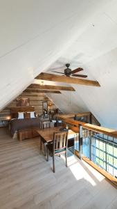 a living room with a ceiling fan and a bed at Domaine Taïga - Parc animalier en forêt in Sainte-Agathe-des-Monts