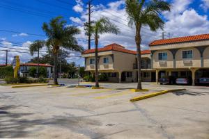 a parking lot in front of a building with palm trees at Orange Tustin Inn in Orange in Orange