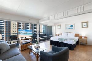 a bedroom with a bed and a living room at Ilikai Tower 1538 condo in Honolulu
