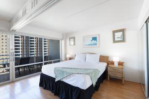 a bedroom with a large bed and a balcony at Ilikai Tower 1538 condo in Honolulu