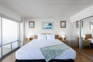 a bedroom with a large bed and a balcony at Ilikai Tower 1538 condo in Honolulu