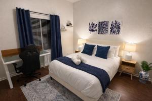 a bedroom with a bed with blue pillows and a desk at Peaceful Inn at Deerfield Beach Boca Raton in Deerfield Beach