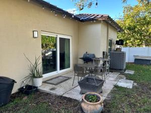 a patio with a table and chairs next to a house at Peaceful Inn at Deerfield Beach Boca Raton in Deerfield Beach