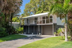 a house with palm trees in front of it at Boo's Place in Blueys Beach