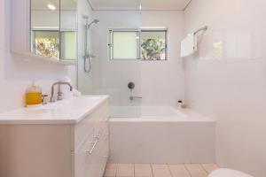 a white bathroom with a sink and a shower at Boo's Place in Blueys Beach +14 photos