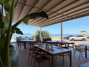 a restaurant with tables and chairs with a view of the beach at Riviera Boutique Hotel by Pomo d'oro in Vlorë