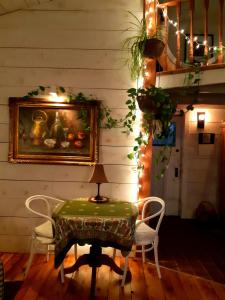 a table and chairs in a room with a painting on the wall at Longview Spectacular Forest Views on 88 Acres in Westport