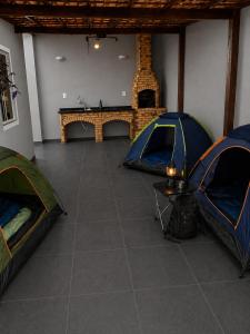 two tents in a room with a table and a fireplace at Heyco camping e hospedaria in Cabo Frio