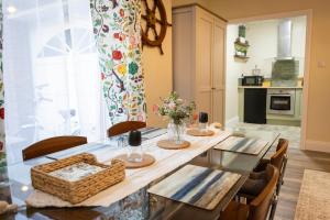 a dining room with a table with a basket of flowers at The Wheelhouse, Ballycastle in Ballycastle
