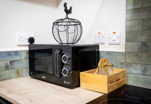 a microwave on a counter with a bird on top of it at The Wheelhouse, Ballycastle in Ballycastle +95 photos
