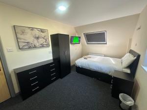 a bedroom with a bed and a dresser at Park hotel in Bradford