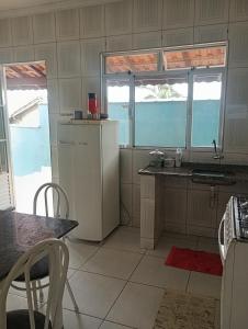 a kitchen with a refrigerator and a table and two windows at Alta Vista in Penedo