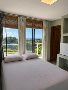a bedroom with a large bed with a large window at Casa Luar da Sereia - Itacaré in Itacaré +46 photos