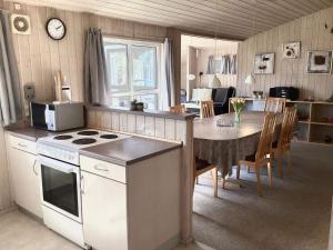 eine Küche und ein Esszimmer mit Herd und Tisch in der Unterkunft 6 person holiday home in Nørre Nebel-By Traum in Nørre Nebel