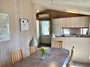 eine Küche mit einem Tisch, auf dem eine Blumenvase steht in der Unterkunft 6 person holiday home in Nørre Nebel-By Traum in Nørre Nebel + 17 Fotos