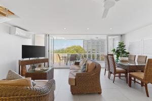 a living room with a couch and chairs and a television at Spinnaker Quays in Mooloolaba
