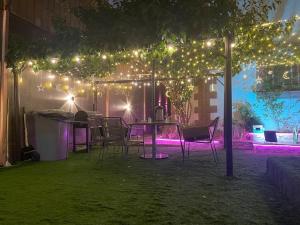 a table and chairs under a pergola with lights at دار ناصر in Riyadh