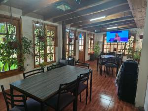 a dining room with tables and chairs and a flat screen tv at Hostal Fernanda in Santa Cruz