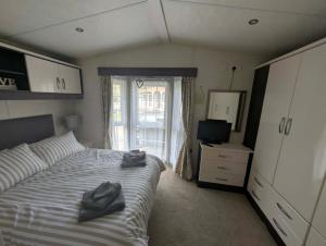 a bedroom with a bed with two pairs of shoes on it at J&J Retreat in Morpeth +9 photos
