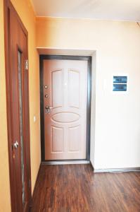 pasillo vacío con puerta blanca y suelo de madera en Apartments KSGM London at Gamarnika 6A, en Khabarovsk