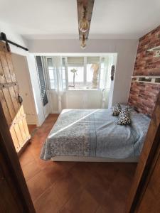 a bedroom with a bed and a brick wall at Beach house in Rincón de la Victoria