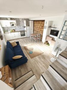 a living room with a blue couch and a kitchen at Beach house in Rincón de la Victoria