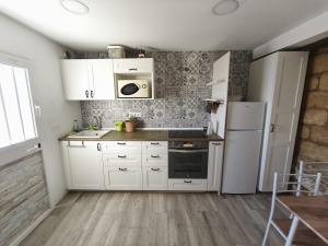 a kitchen with white cabinets and a white refrigerator at Beach house in Rincón de la Victoria