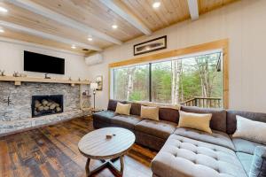 a living room with a couch and a fireplace at River House in North Creek