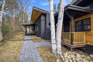 a log cabin with a walkway next to a house at River House in North Creek