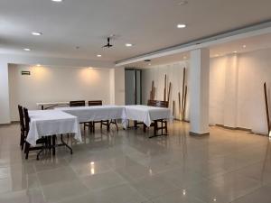a dining room with white tables and chairs at Hotel Soberanis in Cancún