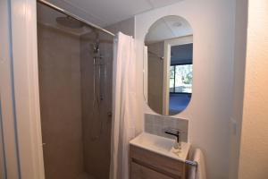 a bathroom with a sink and a shower with a mirror at Tanderra 17 28 Park Road in Jindabyne +7 photos