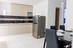 a kitchen with a refrigerator and a table and chairs at Apartamento 201 - a 5 minutos del centro de Pitalito in Pitalito