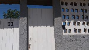 a white garage door with a building in the background at Cantinho da Alzira - Sobrado in Iguaba Grande +28 photos