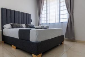 a bedroom with a large bed with a black headboard at Apartamento 201 - a 5 minutos del centro de Pitalito in Pitalito