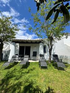 a group of chairs sitting in the grass in front of a house at Villa Valentina-Sunny 2 Bedroom House with Pool in Carvoeiro