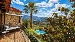 a house with a balcony with a pool and palm trees at Casa Favo de Mel - Jacuzzi & Piscina - Refúgio na Montanha in Arcos de Valdevez