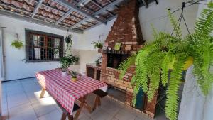 a patio with a table and a brick fireplace at Coliving Stela Mares in Florianópolis