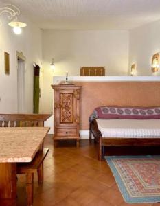 a bedroom with a bed and a bench and a table at NURAS - Gioberti Charme House in Alghero