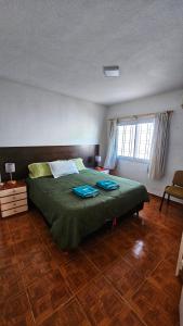 a bedroom with a bed with green sheets and a window at Hospedaje SUEÑO URBANO in Córdoba