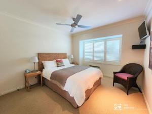 a bedroom with a bed and a window and a chair at Bay Suite - Waterfront Apartment in Metung in Metung