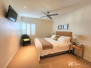 a bedroom with a bed and a flat screen tv at Bay Suite - Waterfront Apartment in Metung in Metung