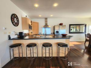 a kitchen with a counter and bar stools at Bay Suite - Waterfront Apartment in Metung in Metung