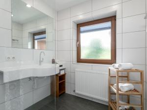 a white bathroom with a sink and a window at Zellner Top 9 in Alpbach +32 photos