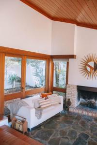 a living room with a white couch and a fireplace at Casa com 4 quartos e Jardim Espaçoso - Santa Sofia in Moledo