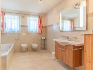 a bathroom with a sink and a tub and a toilet at Haus am Bad in Bad Häring +35 photos