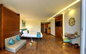 a hotel room with a bed and a couch at Roopa Elite in Mysore