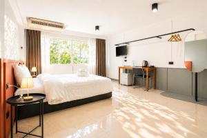 a bedroom with a bed and a desk in it at Quicky Stay Hotel Suphanburi in Suphan Buri