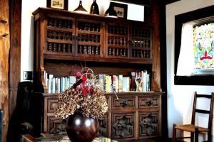 a vase with flowers on a table next to a book shelf at Le Temps Perdu in Westport