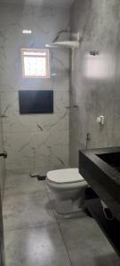 a bathroom with a white toilet and a window at Casa Flórida in Uberaba +15 photos